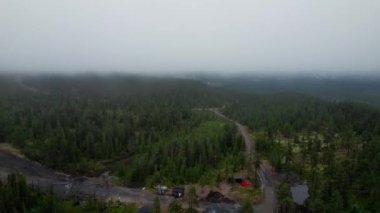 Idre, Dalarna, İsveç 'te sisli bir yaz günü, kayak pisti, kayak asansörü ve çevreleyen yeşil orman dağları yer alıyor. Hava Yüksek Açılı Görünüm Kayak merkezi Idre Fjall