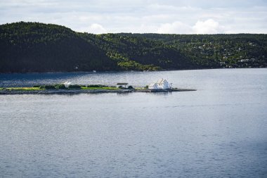 Norveç 'in Oslo Fjord kentindeki küçük kayalık bir adada Steilene Deniz feneri ve arka planda bir dağ ve dağ yamacında Fjellstrand köyü bulunan beyaz bir bina bulunur.