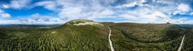 Ulusal park Nipfjallet ve Stadjan dağlarının nefes kesici 360 panoraması, Idre, Dalarna İsveç 'te canlı bir gökyüzü altında yemyeşil ormanlar ve geniş manzaralar sunar..