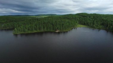 İsveç 'in Jamtland' in güzelliğinin hava takibi, bir gölün kıyısındaki bir barınağın (slogbod) üzerinde süzülen insansız hava aracı gibi. Çevredeki ormanlar rahatlama ve macera için bir zemin oluşturur..