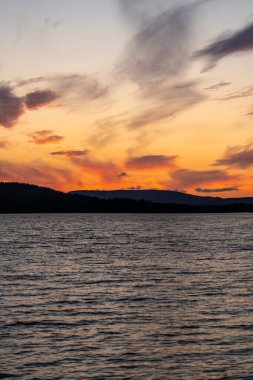 Güneş batarken, canlı renkler İsveç 'teki Langfjallet Doğa Rezervi ile çevrili Hallsjon Gölü' ne yansıyor.