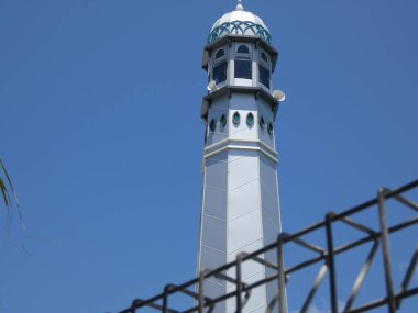 The surrounding trees provide shade, creating a serene and peaceful atmosphere  perfect for themes of religion, culture, architecture, and travel.