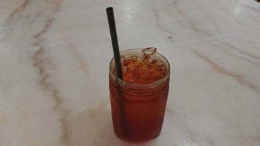 The design features swirling red, green, and yellow motifs with accents of blue flowers and leaf shapes. 