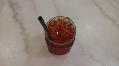 The design features swirling red, green, and yellow motifs with accents of blue flowers and leaf shapes. 