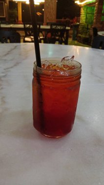 The design features swirling red, green, and yellow motifs with accents of blue flowers and leaf shapes. 