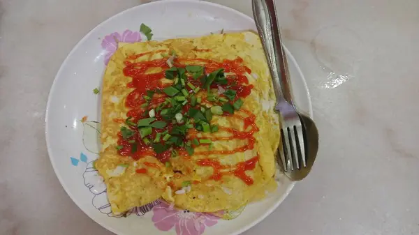 The design features swirling red, green, and yellow motifs with accents of blue flowers and leaf shapes. 