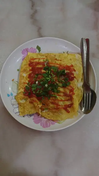 The design features swirling red, green, and yellow motifs with accents of blue flowers and leaf shapes. 