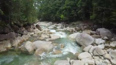 Kayalık oluşumlar arasında akan turkuaz nehir akışının üst görünümü.