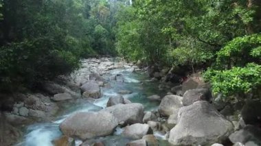 Kayalık oluşumlar arasında akan turkuaz nehir akışının üst görünümü.
