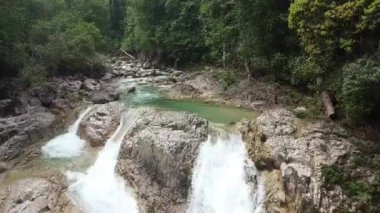 Kayalık oluşumlar arasında akan turkuaz nehir akışının üst görünümü.