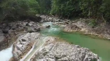 Kayalık oluşumlar arasında akan turkuaz nehir akışının üst görünümü.