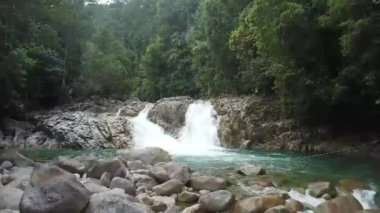 Kayalık oluşumlar arasında akan turkuaz nehir akışının üst görünümü.