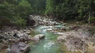 Kayalık oluşumlar arasında akan turkuaz nehir akışının üst görünümü.