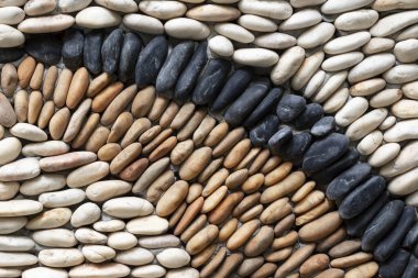 Doğadan esinlenilmiş, bahçe tasarımı için duvarda beyaz, kahverengi ve siyah taşlar bulunan dekoratif taşlar..