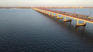 Arabalar ve otobüsler nehir boyunca köprü boyunca gider. Dnipro 'da karayolu köprüsü, Ukrayna' nın Dnepr şehrinde şehir ulaşımı