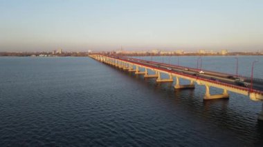 Arabalar ve otobüsler nehir boyunca köprü boyunca gider. Dnipro 'da karayolu köprüsü, Ukrayna' nın Dnepr şehrinde şehir ulaşımı
