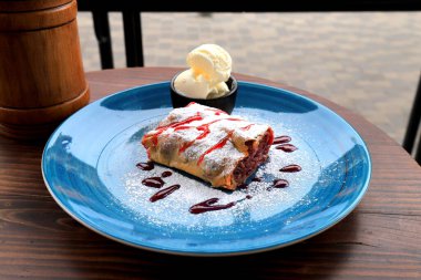 Kafede, restoranda, mavi tabakta Viyana meyveli turta ve dondurma. Sıcak, lezzetli tatlı, Avusturya 'da tatlı puf böreği.