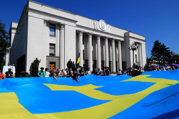 Crimean Tatar flag. Crimea is Ukraine. Patriot People hold large blue flag with yellow tanga emblem near Ukrainian parliament. Russia war against Ukraine, Kyiv, 2021-06-15