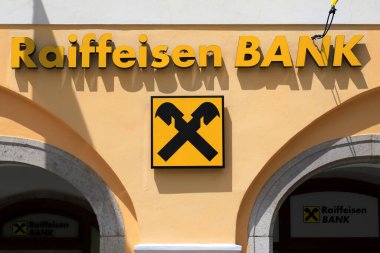 Raiffeisen Bank in medieval town. Signboard and flags large international Raiffeisen Bank are located in Cesky Krumlov, Czech Republic, 2022-06-14 clipart