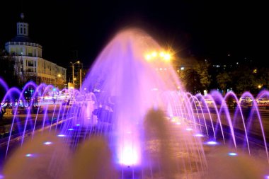 Geceleri renkli ışıklandırmalı çeşme, yaratıcı su tasarımı. Ukrayna, Dnipro şehri.