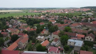 Flight over bohemian countryside with traditional village and red roofs, Czech Republic. Aerial view of town Czech 