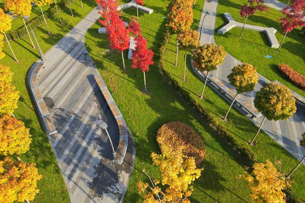 Beautiful autumn park with picturesque yellow orange trees and leaves. Autumn streets in city Dnipro, Ukraine, aerial photo, drone view