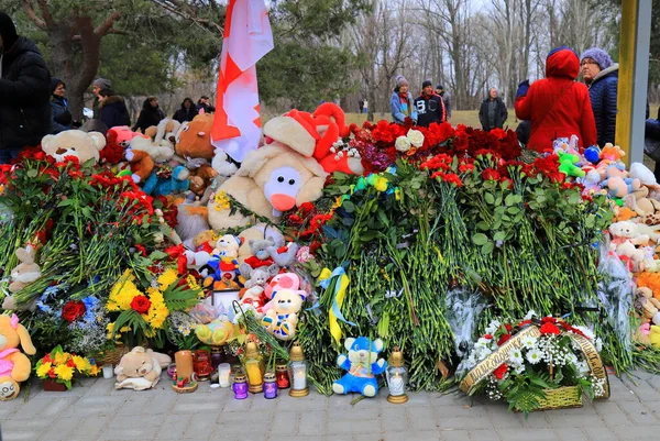 Dnipro, Ukrayna, 2023-01-15 Çiçekler, çocuk oyuncakları, mumlar, Rus füzesi tarafından tahrip edilen konut binasının yakınındaki lambalar. Siviller öldürüldü. Düzinelerce ölü ve yaralı..