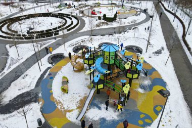 Kış parkı, meydan, çocukların oyun alanı olan, karla kaplı bir sokak. Çocuklar ve yetişkinler kışın slaytlara ve salıncaklara binerler. Dnipro, Ukrayna, İHA 'nın üst görüntüsü