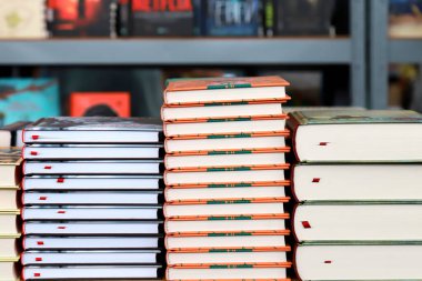 Kitap, not defterleri, defterler kitapçının penceresinde, kütüphanede, kitaplarla dolu rafların arka planına karşı sergilenen kitaplarda.