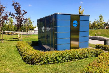 Ukraynaca yazılmış tuvaleti olan tuvaletin modern görüntüsü. Metal bina, açık hava tuvaleti cephesi. Erkekler ve kadınlar için tabelalı..