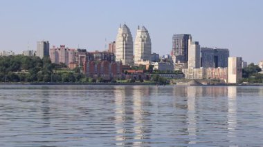 Ukrayna şehri. Dnipro, Ukrayna, güzel modern kuleler, binalar, gökdelenler yaz sabahı erken saatlerde su nehrine yansıyor.. 