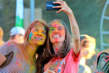 Renk Festivali Holi. Gençler renkli boya atıyor ve Holi festivalinde eğleniyor. Kızlar selfie çeker. Hint tatili. Dnipro, Ukrayna, 2017-08-28