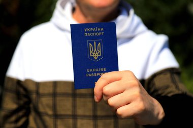 Elinde Ukrayna pasaportu olan Ukrayna pasaportu olan bir adam var. Ukrayna pasaportu. Seyahat konsepti, mülteci, turist, göçmen, seferberlik, göçmen.