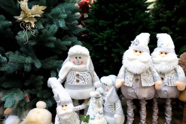 Noel ve yeni yıl oyuncakları ve süslemeleri. Komik güzel cüceler, kardan adamlar, Noel ağacının altındaki bebekler. Şenlikli kış festivali, alışveriş merkezinde indirim.