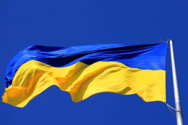 Mavi gökyüzünde dalgalanan Ukrayna bayrağı. Büyük sarı Ukrayna bayrağı, Dnipro.