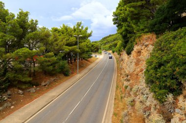 Hırvatistan 'daki dağ yolu yüksek dağlar, tepeler, çam ormanları arasında. Hırvat otoyolu, otobanı ve seyahatinde arabalar sürüyor