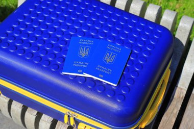 Ukrayna 'da yazılı 2 Ukrayna pasaportu - Ukrayna bayrağı renginde sarı mavi bavulda Ukrayna pasaportu bulunuyor. Seyahat, mülteciler, turizm, göç, seferberlik, göçmenler