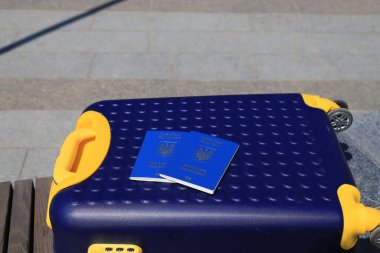 Ukrayna 'da yazılı 2 Ukrayna pasaportu - Ukrayna bayrağı renginde sarı mavi bavulda Ukrayna pasaportu bulunuyor. Seyahat, mülteciler, turizm, göç, seferberlik, göçmenler