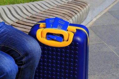 Ukrayna 'da yazılı 2 Ukrayna pasaportu - Ukrayna bayrağı renginde sarı mavi bavulda Ukrayna pasaportu bulunuyor. Seyahat, mülteciler, turizm, göç, seferberlik, göçmenler