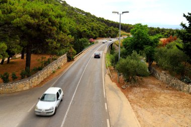 Hırvatistan 'daki dağ yolu yüksek dağlar, tepeler, çam ormanları arasında. Hırvat otoyolu, otobanı ve seyahatinde arabalar sürüyor