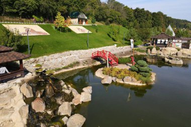 Uman, Ukrayna, 09-12 2021. New Sofiyivka 'da Japon tarzı güzel bir peyzaj parkı. Göl, ahşap ağaçlar, kırmızı köprü, parktaki insansız hava aracı manzarası..