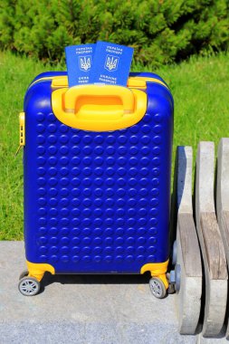 Ukrayna 'da yazılı 2 Ukrayna pasaportu - Ukrayna bayrağı renginde sarı mavi bavulda Ukrayna pasaportu bulunuyor. Seyahat, mülteciler, turizm, göç, seferberlik, göçmenler