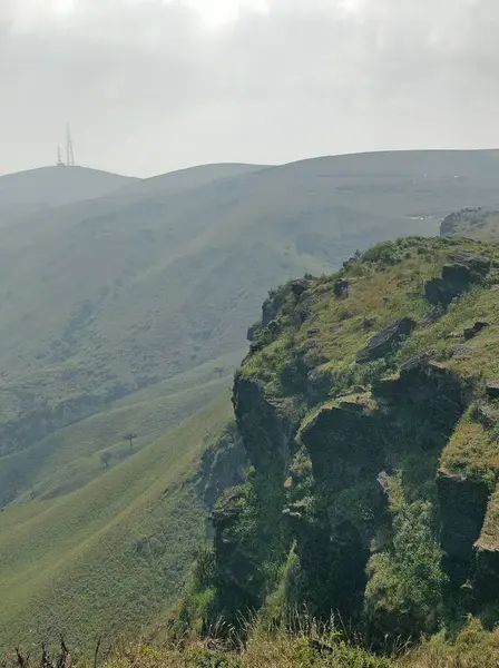 Baba Budan Giri dağ sırasının panoramik manzarası, kayan tepeler, yemyeşil vadiler ve engebeli uçurumlar. Uzak tepeler gizem ve cazibe hissi uyandıran sislerle kaplıdır..