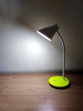 Masa lambası, karanlık bir arkaplanda parlıyor..