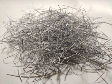 Yüksek açı, tarafsız bir arkaplanda gri, beyaz ve siyah kağıt yığınını gösteriyor. İnce şeritler ince gölgelerle yoğun bir kütle oluşturarak derinlik ve dinamik düzensizlik hissi ekliyor..