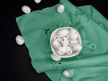 Üst Manzara. Mutlu Paskalyalar. Beyaz Paskalya bıldırcın yumurtaları, el yapımı yeşil peçete genişliği siyah arka planda yumuşak pamuk. Metin için boşluk ile bahar şablonu. Tebrik kartı ya da afiş. 