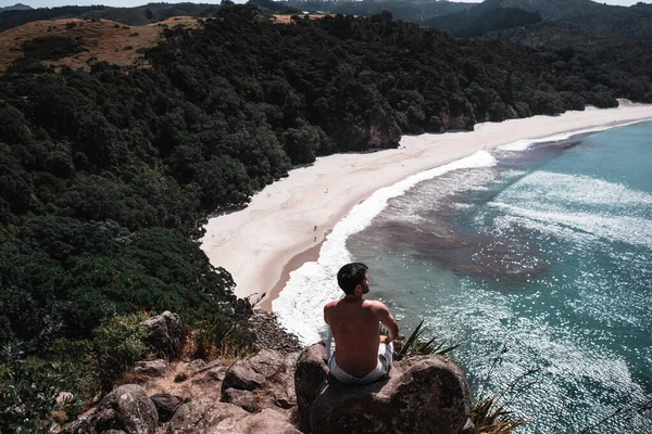 Hayat Tarzı Seyahat Konsepti 'nde kayaların üzerinde oturan genç adam.