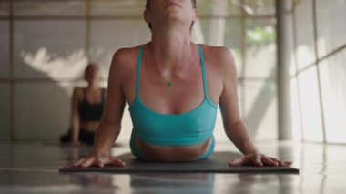 Yoga dersinde gerinen bir kadının ön görüntüsü - yakın çekim - 4K Yatay video