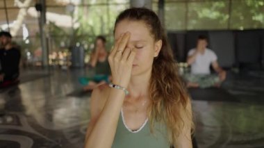 Rahat kadın portresi, gözleri kapalı, arka planda bulanık insanlar - 4K Yatay video