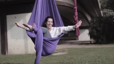 İspanyol kız, kollarını açmış parktaki havadan yoga elbisesine sarılıyor.